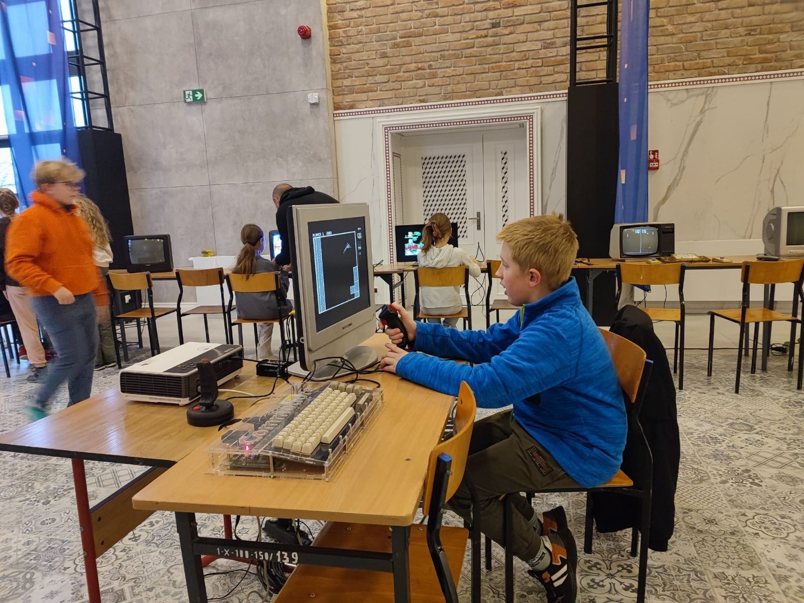 uczniowie 5a oglądają sprzęt komputerowy z lat 80-tych