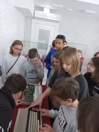 uczniowie 5b oglądają sprzęt komputerowy z lat 80-tych