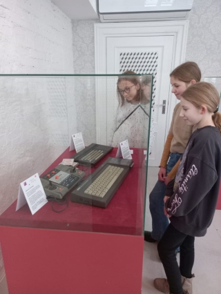 uczniowie 5b oglądają sprzęt komputerowy z lat 80-tych