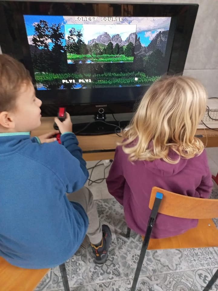 uczniowie 5b oglądają sprzęt komputerowy z lat 80-tych