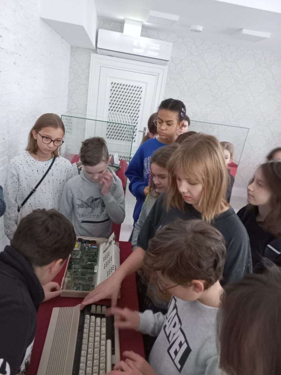 uczniowie 5b oglądają sprzęt komputerowy z lat 80-tych