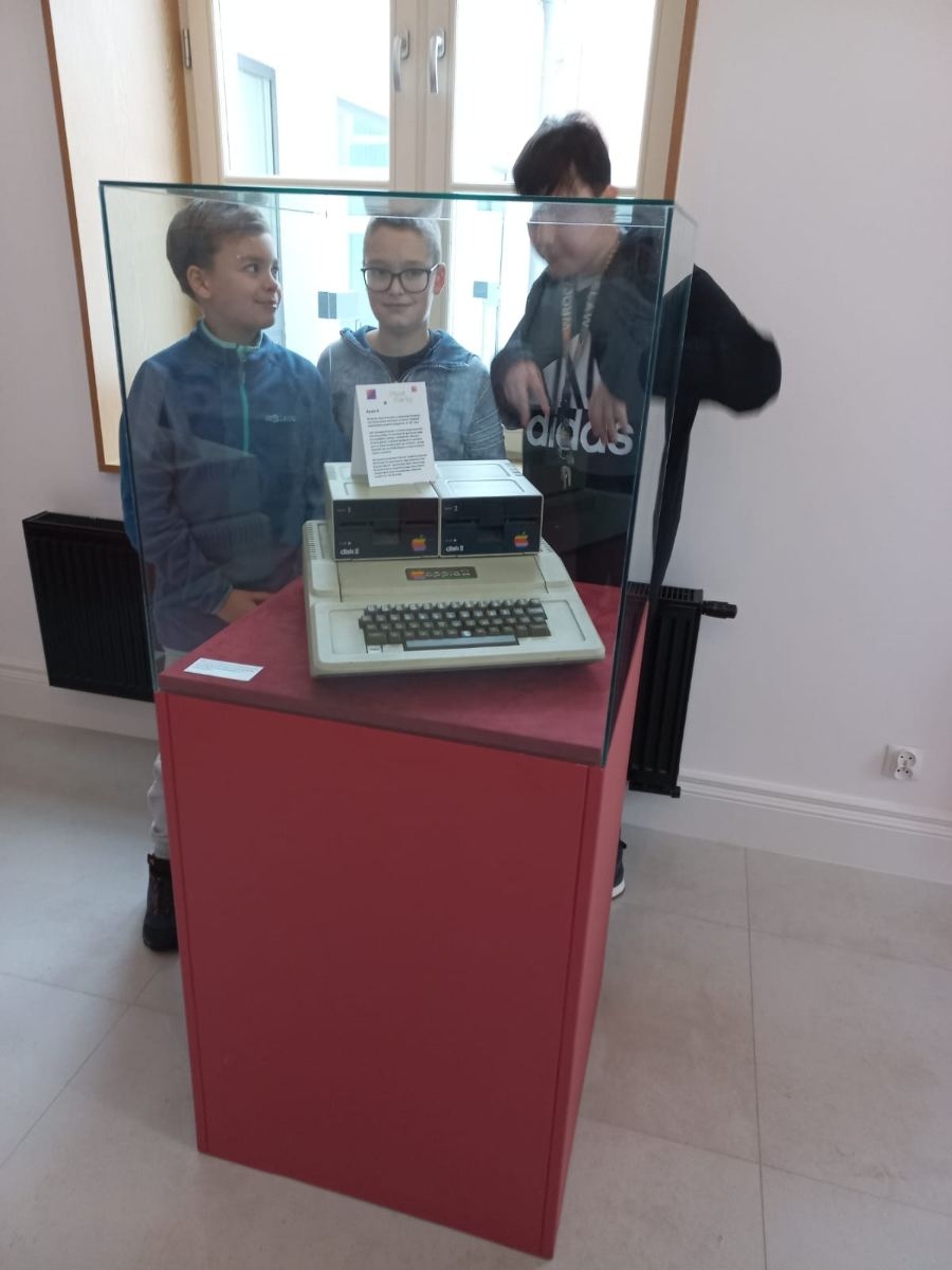 uczniowie 5b oglądają sprzęt komputerowy z lat 80-tych