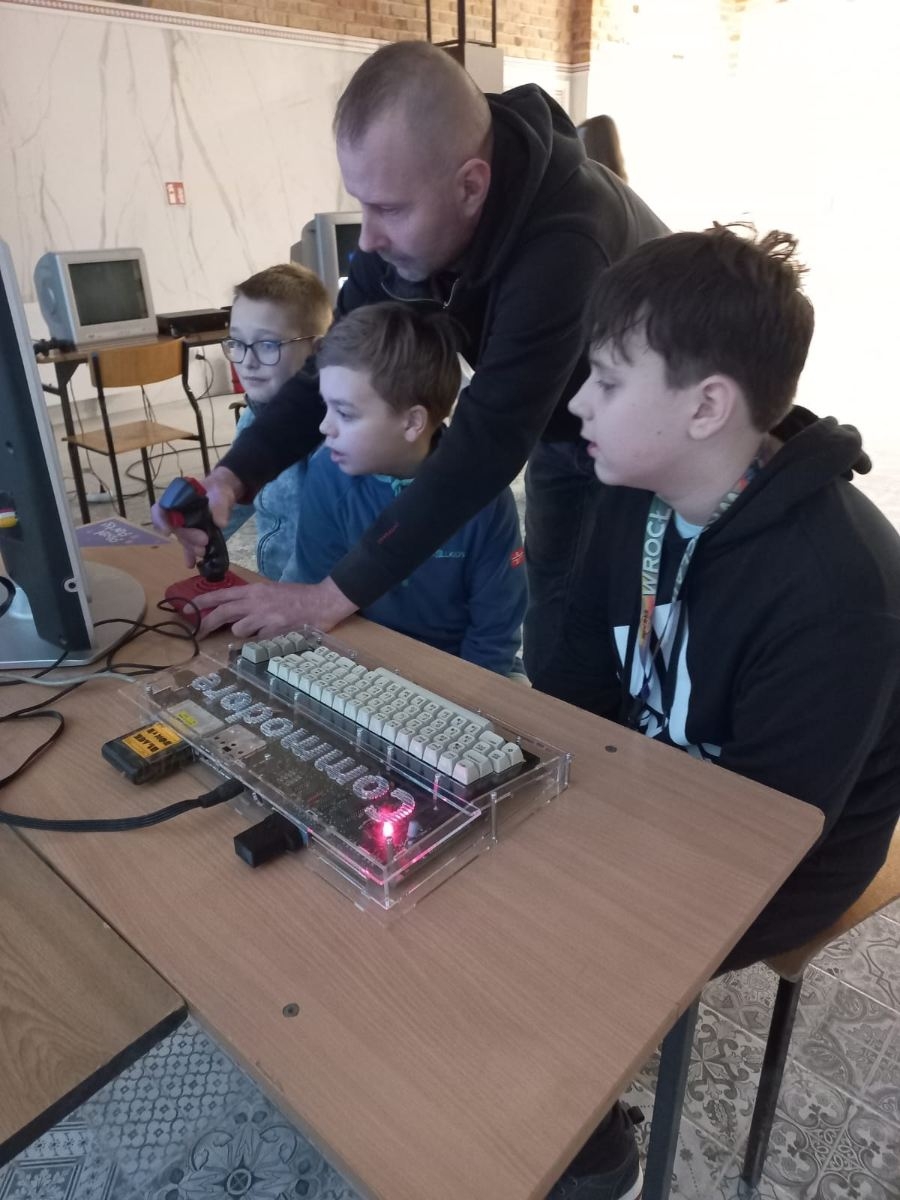 uczniowie 5b oglądają sprzęt komputerowy z lat 80-tych