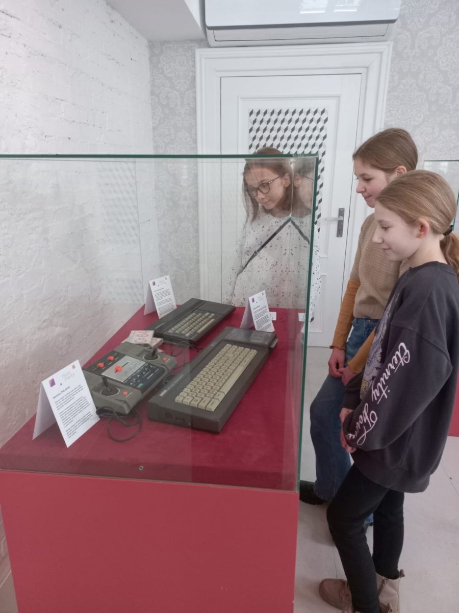 uczniowie 5b oglądają sprzęt komputerowy z lat 80-tych