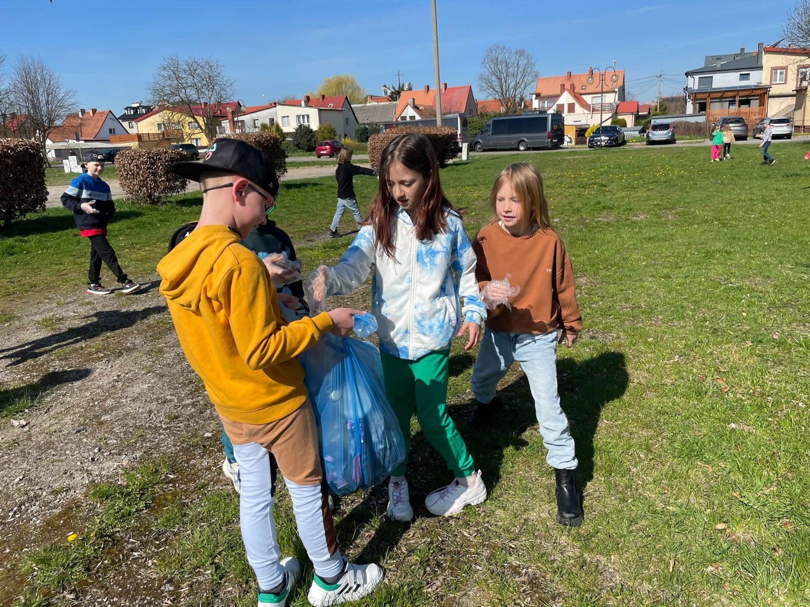 Uczniowie 2b podczas sprzątania terenów w pobliżu szkoły