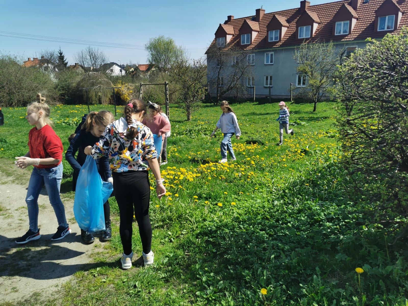 Uczniowie 3b podczas sprzątania terenów w pobliżu szkoły