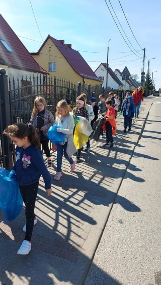 Uczniowie klas 1 podczas sprzątania terenów w pobliżu szkoły