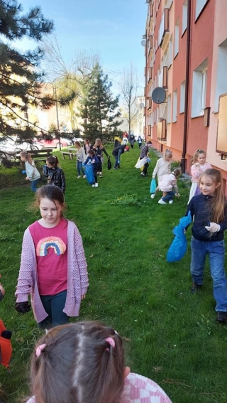 Uczniowie klas 1 podczas sprzątania terenów w pobliżu szkoły