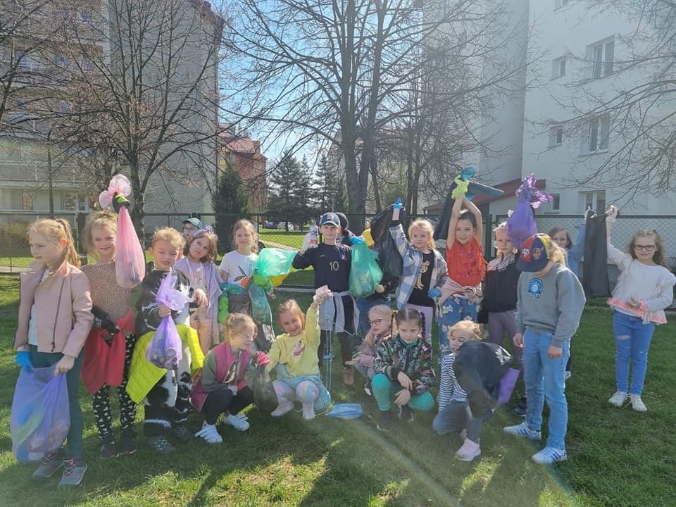 Uczniowie klas 1 podczas sprzątania terenów w pobliżu szkoły