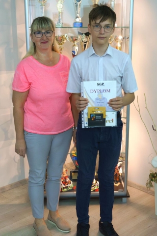 nagrodzony uczeń z nauczycielem