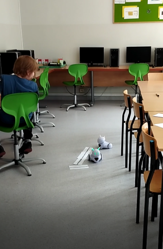 uczniowie na kole informatycznym uczą się programowania roboty