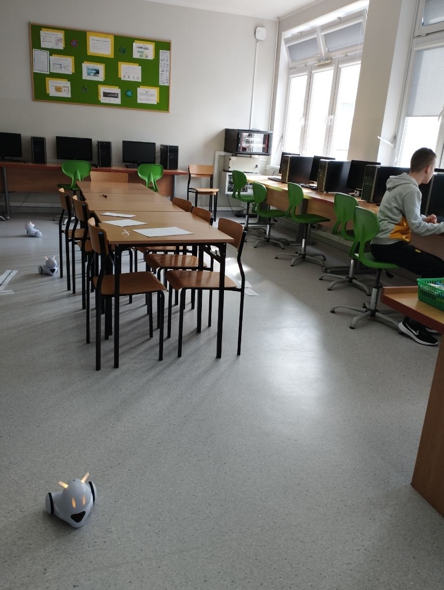 uczniowie na kole informatycznym uczą się programowania roboty