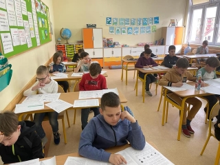 uczniowie siedzący na sali - rozwiązują zadania