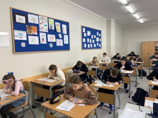 uczniowie siedzący na sali - rozwiązują zadania